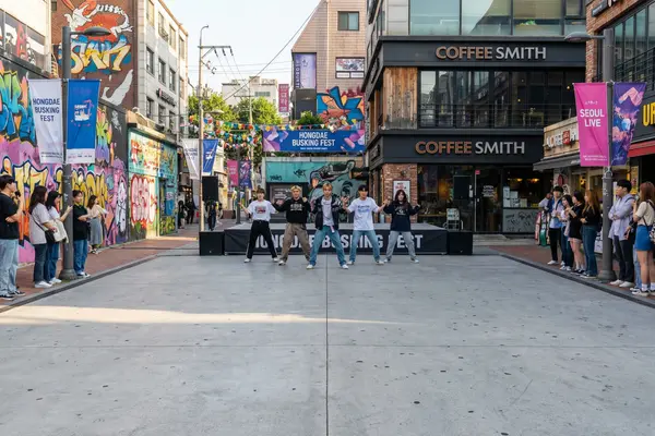 Street performance and passing movement shaping Hongdae's public culture mood